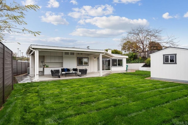 rear view of house featuring a lawn, outdoor lounge area, a fenced backyard, an outdoor structure, and a patio