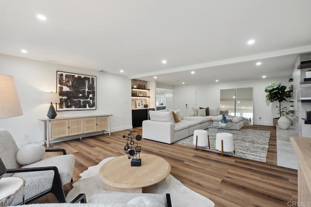 living area featuring recessed lighting, baseboards, and wood finished floors