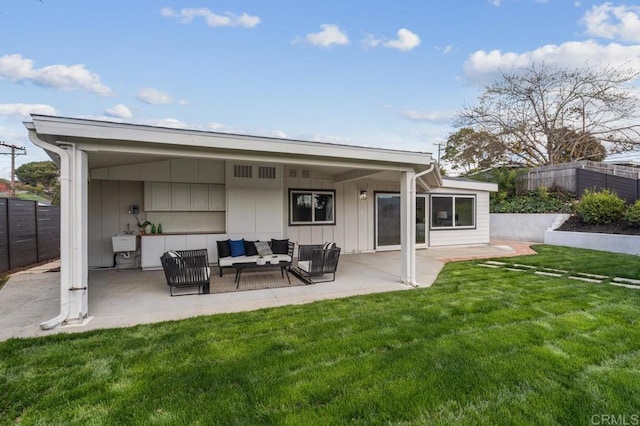 back of house featuring an outdoor living space, fence, a patio area, and a lawn