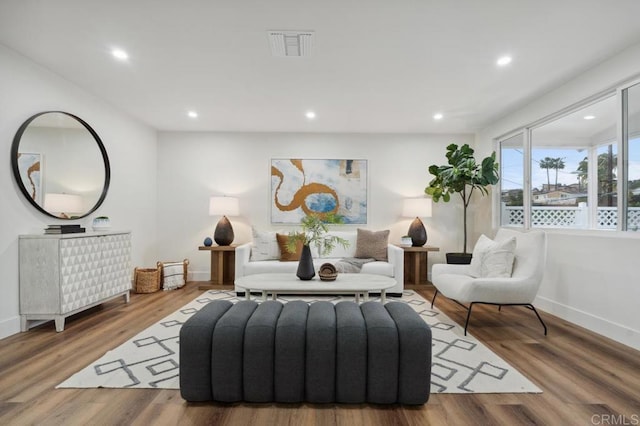 living room featuring recessed lighting, visible vents, baseboards, and wood finished floors