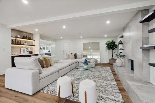 living area featuring a fireplace, recessed lighting, wood finished floors, and baseboards