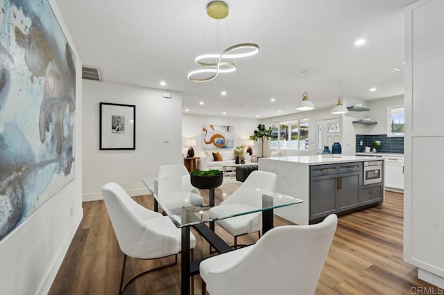 dining room with recessed lighting, visible vents, a healthy amount of sunlight, and wood finished floors