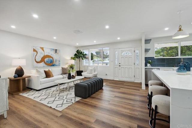 living area with recessed lighting, a healthy amount of sunlight, and wood finished floors