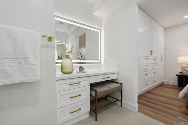 bathroom featuring vanity, visible vents, wood finished floors, and baseboards