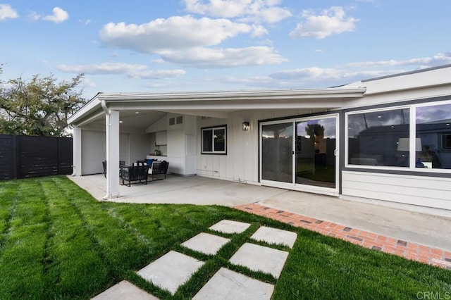 back of property featuring a lawn, a patio, and fence