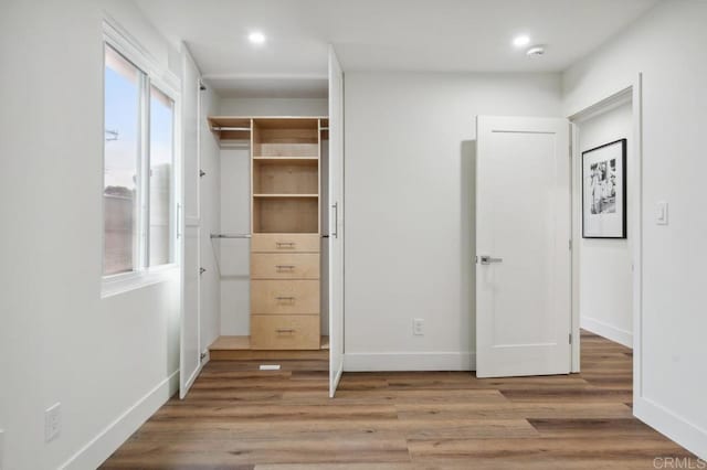 unfurnished bedroom with recessed lighting, wood finished floors, and baseboards