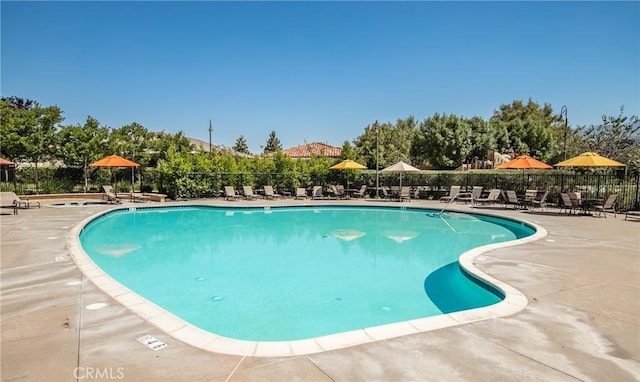 community pool featuring a patio area and fence