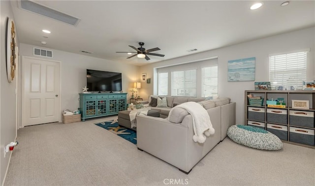 living area featuring visible vents, carpet, and ceiling fan