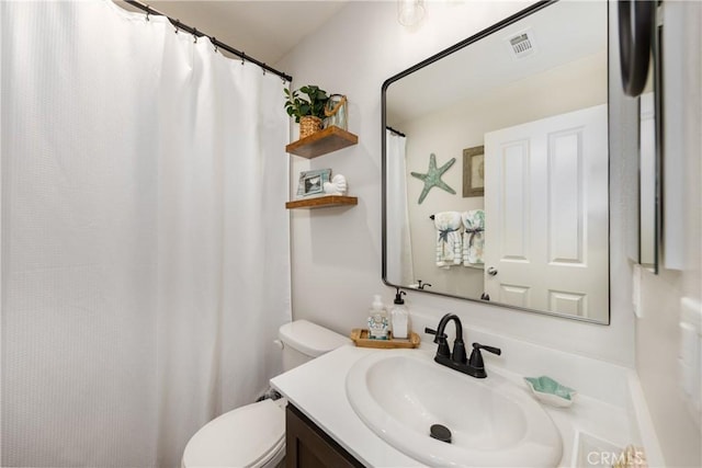 bathroom with vanity, toilet, and visible vents