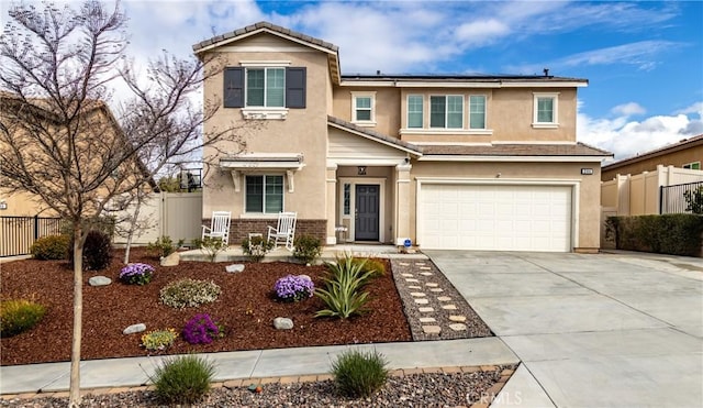 traditional-style home featuring fence, driveway, an attached garage, stucco siding, and roof mounted solar panels