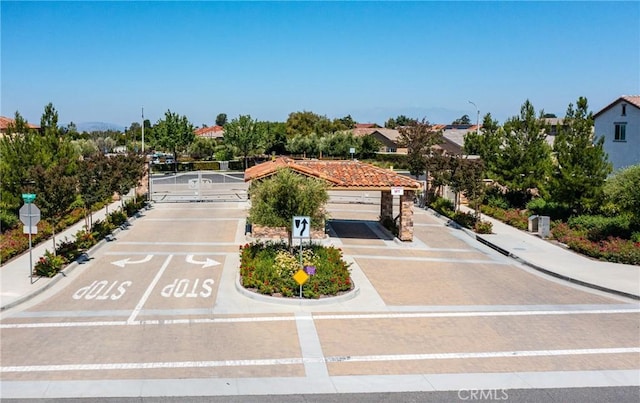 exterior space with a gated entry, curbs, traffic signs, and sidewalks