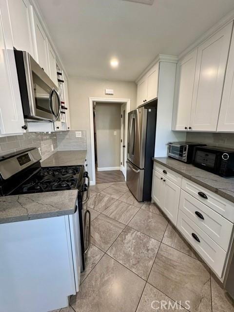 513 W Commonwealth Ave, Alhambra, CA 91801 - kitchen with light stone counters, backsplash, appliances with stainless steel finishes, a toaster, and white cabinets