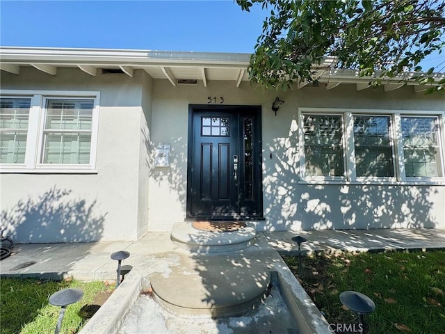 view of exterior entry with stucco siding