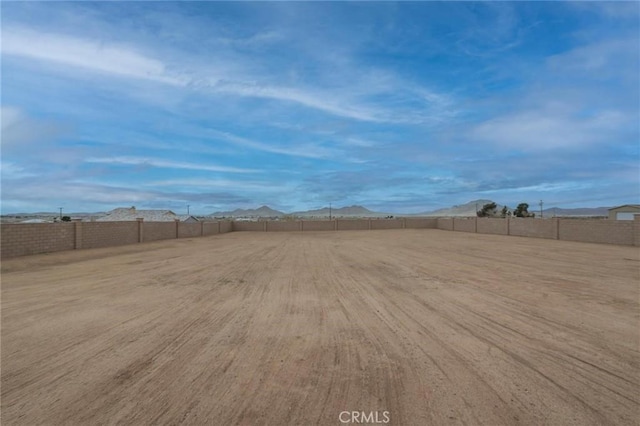 view of yard featuring fence and a mountain view