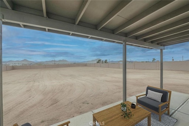 view of patio featuring a mountain view and fence