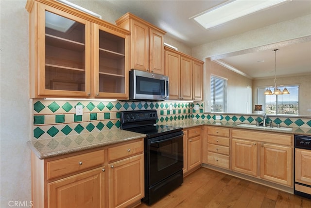 kitchen featuring stainless steel microwave, paneled dishwasher, wood finished floors, black / electric stove, and a sink