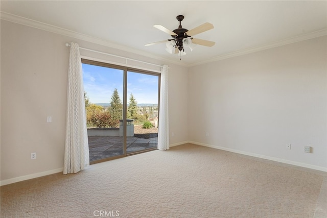 carpeted spare room with baseboards, crown molding, and ceiling fan