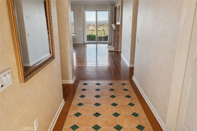 hallway with tile patterned floors and baseboards