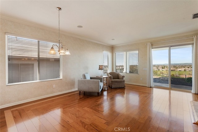 sitting room featuring crown molding, an inviting chandelier, and wood finished floors