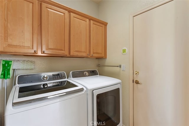 clothes washing area with cabinet space and washer and clothes dryer