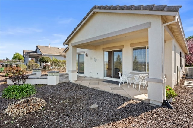 back of house with a patio, cooling unit, and stucco siding