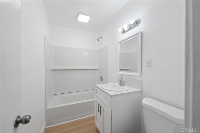 bathroom featuring toilet, vanity, shower / bathing tub combination, and wood finished floors