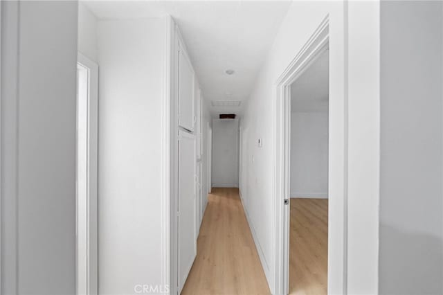 hallway with baseboards and light wood finished floors