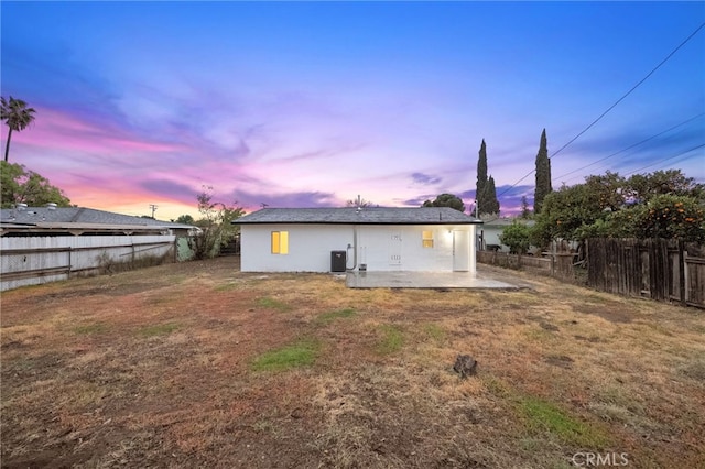 rear view of house with a yard, a fenced backyard, and a patio area