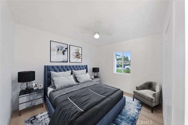 bedroom featuring baseboards, a ceiling fan, and wood finished floors