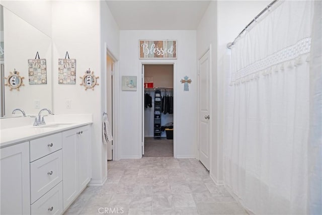 full bath with vanity and a spacious closet