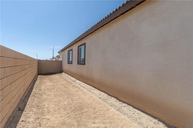 view of home's exterior with stucco siding and a fenced backyard