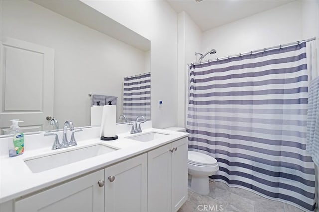 bathroom featuring a sink, toilet, double vanity, and tile patterned floors