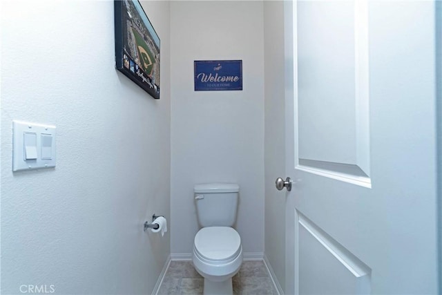 bathroom with tile patterned floors, toilet, and baseboards