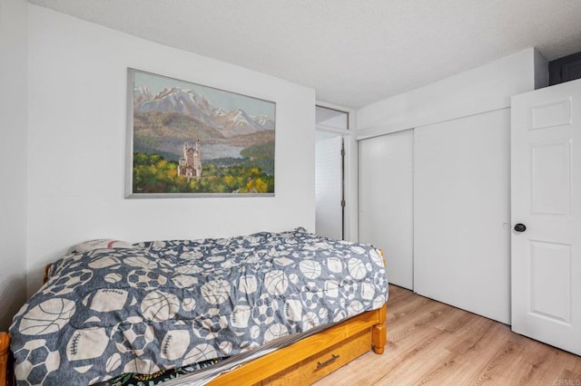 bedroom featuring a closet, a textured ceiling, and wood finished floors