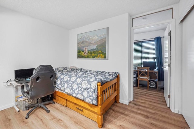 bedroom featuring baseboards and wood finished floors