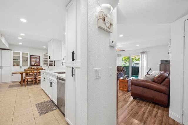 interior space with stainless steel dishwasher, open floor plan, recessed lighting, white cabinets, and light tile patterned floors