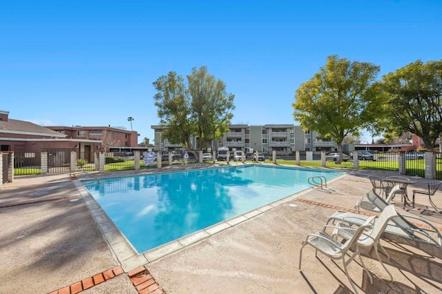 pool featuring a patio area, a residential view, and fence