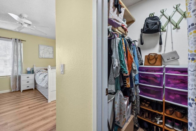 spacious closet featuring wood finished floors and a ceiling fan