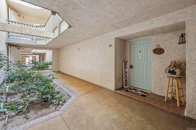 view of exterior entry featuring stucco siding and a balcony