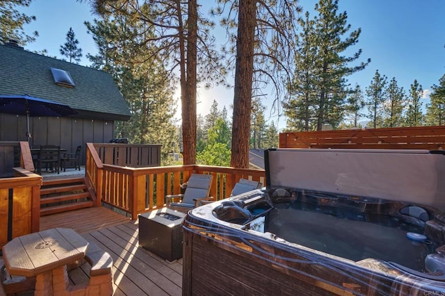 wooden terrace with outdoor dining space and a hot tub