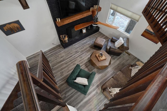 living area featuring a fireplace, stairs, and wood finished floors