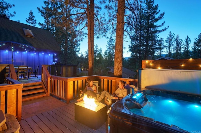 wooden deck featuring outdoor dining space, a hot tub, and an outdoor fire pit