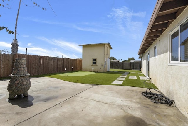 view of patio / terrace featuring an outbuilding, a fenced backyard, and a shed