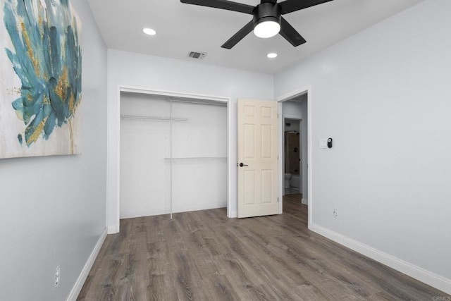 unfurnished bedroom with visible vents, baseboards, a closet, and wood finished floors