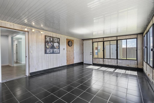 tiled empty room featuring baseboards