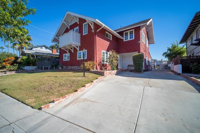 view of front facade with fence, concrete driveway, a front lawn, and a gate