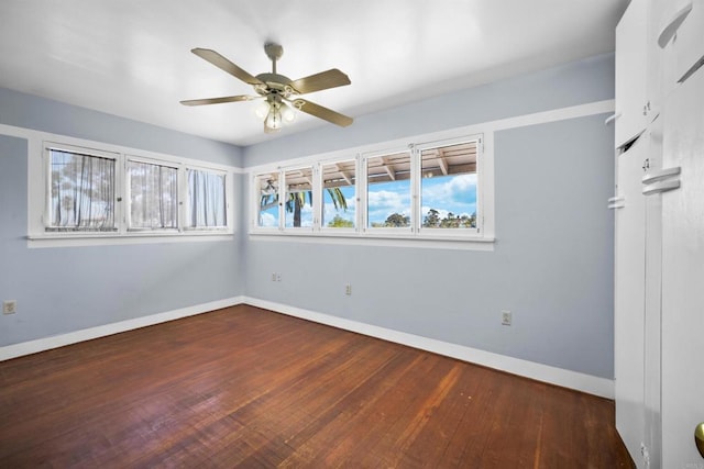 spare room featuring baseboards, a ceiling fan, and wood-type flooring