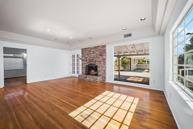 unfurnished living room with visible vents, wood finished floors, recessed lighting, and a fireplace