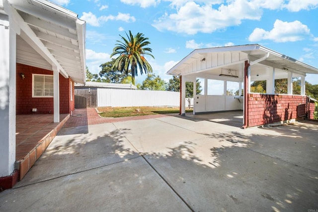 view of patio featuring driveway and fence