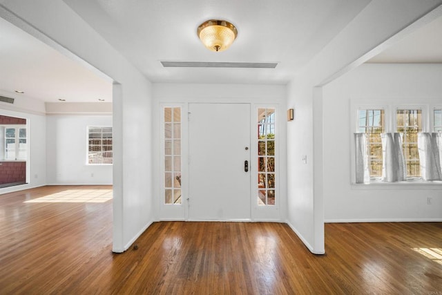 entryway with baseboards, visible vents, and wood finished floors